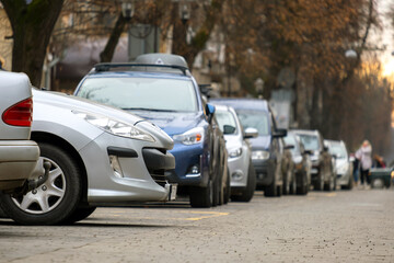 Cars parked in a row on a city street side.