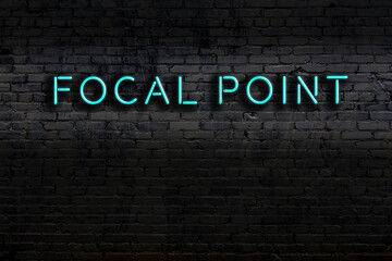 Night view of neon sign on brick wall with inscription focal point