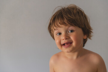 precioso y guapo bebé bajo fondo blanco con preciosa sonrisa y pose natural  enseñando los...