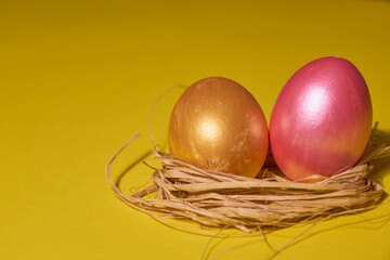 Pearl colored eggs in the nest on a yellow background.