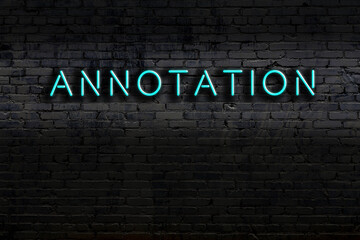 Neon sign. Word annotation against brick wall. Night view