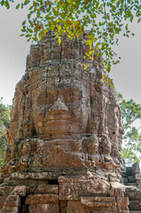 Obraz premium VIEWS OF ANKOR WAT TEMPLES - TOWERS WITH FACES- VEGETATION GROWING OVER BUILDINGS. COLORED RUINS, TEMPLES WITH HISTORY AND INCREDIBLE ARCHITECTURE