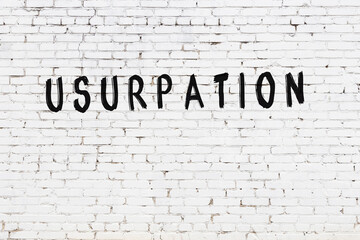 White wall with black paint inscription usurpation on it
