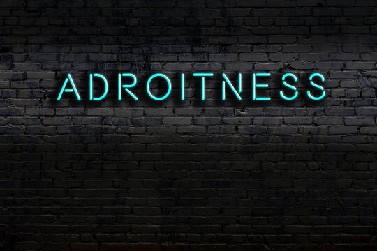 Neon sign. Word adroitness against brick wall. Night view