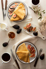 Crepes, thin pancakes with honey on a white plate. Marble background. Top view.