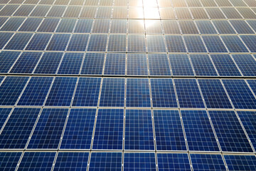 Aerial view of surface of blue photovoltaic solar panels mounted on building roof for producing clean ecological electricity. Production of renewable energy concept.