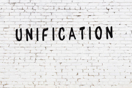 White wall with black paint inscription unification on it