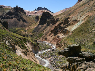 Valley at the bottom of Cerro Colorado. Jagged rock formations jut out of the young mountain range.