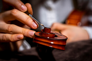 young Chinese violin maker at work in her workshop - obrazy, fototapety, plakaty