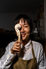 young Chinese violin maker at work in her workshop