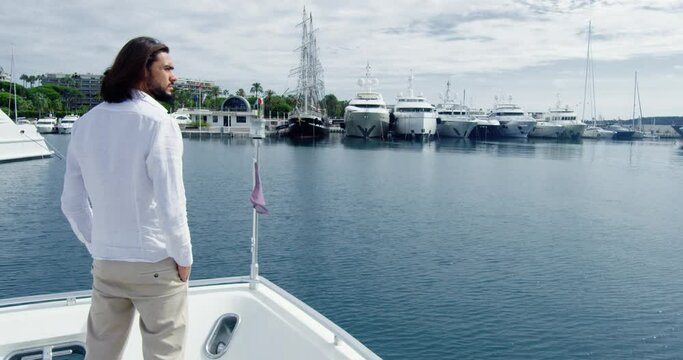 Man from behind standing on a boat sailing into the seagate, under the sunlight - Cinematic scene with RED Camera 4K H264