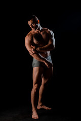Healthy muscular young man on a dark background