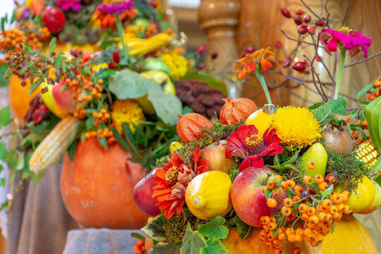 Autumn thanksgiving arrangement with flowers and autumn fruits, pumpkins, apples, sempervivum, colorful background