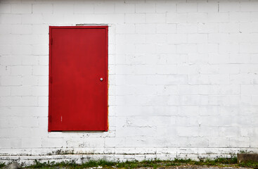 closed red door of abandoned white building