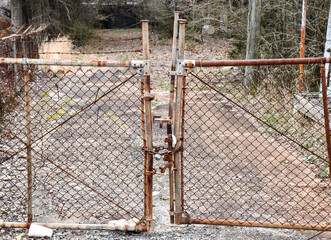 closed chain link fence gate to abandoned warehouse