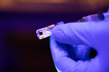 Vial of unmarked vaccine being transferred into needle