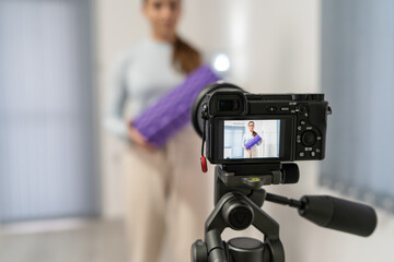 Front view on young caucasian woman at home recording and streaming online video on camera for online training - Girl using foam roller for workout in room - health and fitness concept