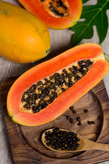 Fresh papaya cut in half on a wooden table