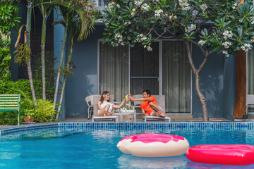 couple having goodtime together on summer vacation in resort and hotel garden beside pool