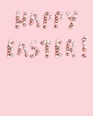 Words  Happy Easter from Chocolate Quail eggs on pastel background. Small pink egg, spring Easter holiday