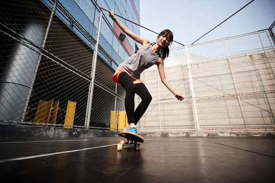 young asian skateboarder skateboarding outdoors