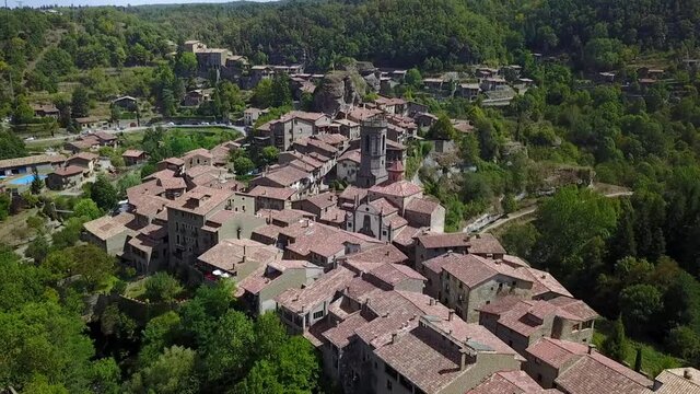 Aerial Backward: Houses In Town Near Green Mountains Against Sky