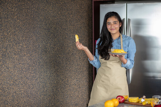 Mujer joven mexicana con un desayuno de pi&ntilde;a en la cocina