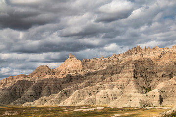 Fototapeta premium low cotton like summer clouds covering the sky in Badlands National Park in South Dakota.
