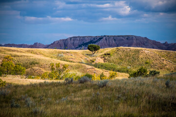 dramatic rock formations and open grasslands in Badlands national park in South Dakota.