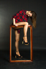 A young, beautiful woman in a red plaid shirt with long brown hair.