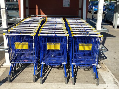 Saint Denis, Réunion France - March 1st 2021: Liberating a row of Carrefour's Chaudron shopping cart trolley with a coin