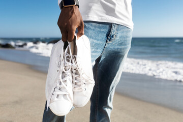 White sneakers closeup men’s apparel summer fashion beach photoshoot