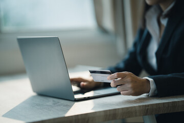 Business women are using credit cards to shop at LabTop concept online shopping.