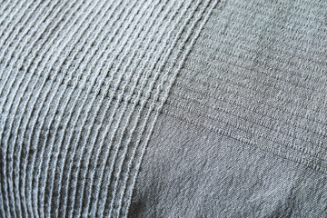 Square embroidery pattern. Gray plaid on the bed.