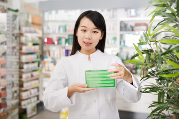 Chinese female pharmacist demonstrating assortment of pharmacy. High quality photo