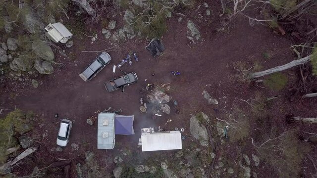 Aerial Top Ascend: People And Vehicles At Campsite In Forest