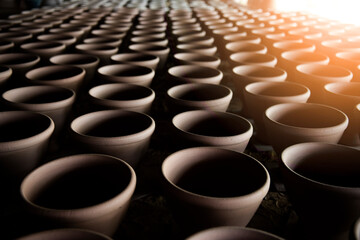 Fototapeta premium A narrow depth-of-field, blurred background and a large traditional indigenous pottery jar sits side-by-side in an Asian stone mortar pottery.