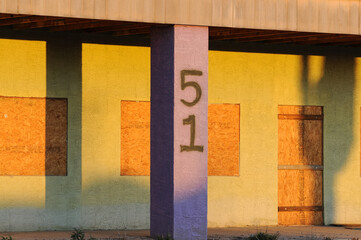 Abandoned commercial building with doors and windows covered with plywood