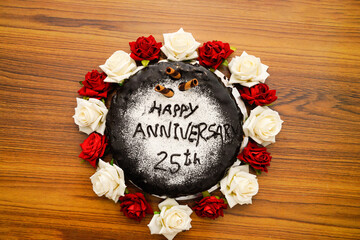Decorative chocolate cake for 25th anniversary on wooden table