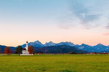 Beautiful view of the Saint Coloman church near the Neuschwanstein castle, against the backdrop of the beautiful mountains, Schwangau in the Bavarian province