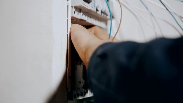 An electrician assembles an electrical panel in an apartment.