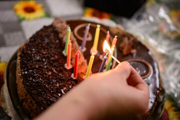Name cake with colored burning candles, holiday and mood.