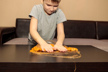 boy plays with orange slime.