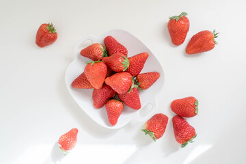 red strawberries in plate on the white table