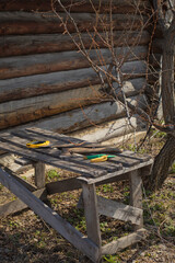 Naklejka premium gardening tools on a wooden table against the background of a log wall