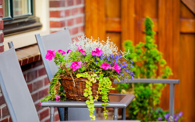 Fototapeta na wymiar Table, chairs and flowers near house.