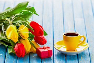 Cup and gift box with bouquet of tulips