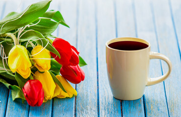 Cup of coffee and bouquet of tulips