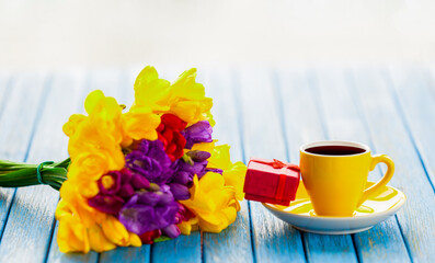Cup of coffee and gift box with flowers