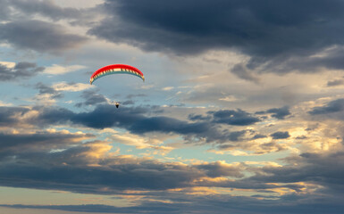 Paraglider flying in the beautiful sky against the background of clouds.